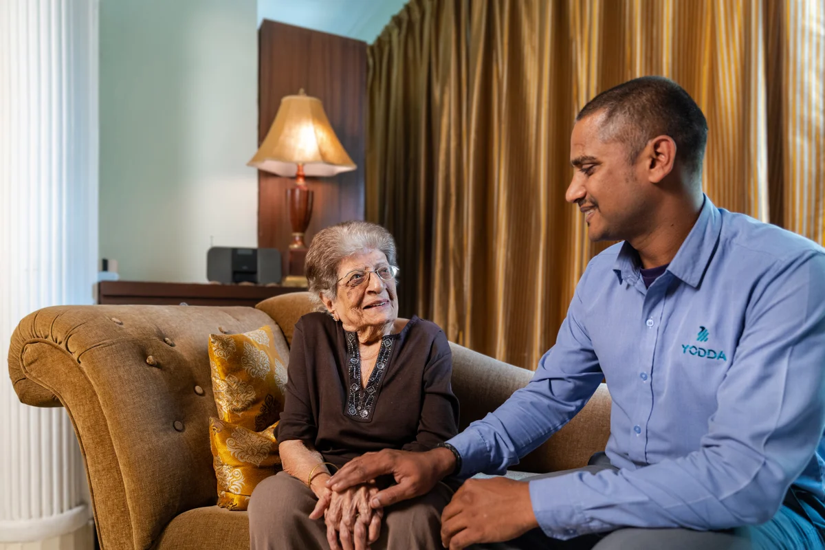 A Yodda representative talking with an older woman during a visit at home